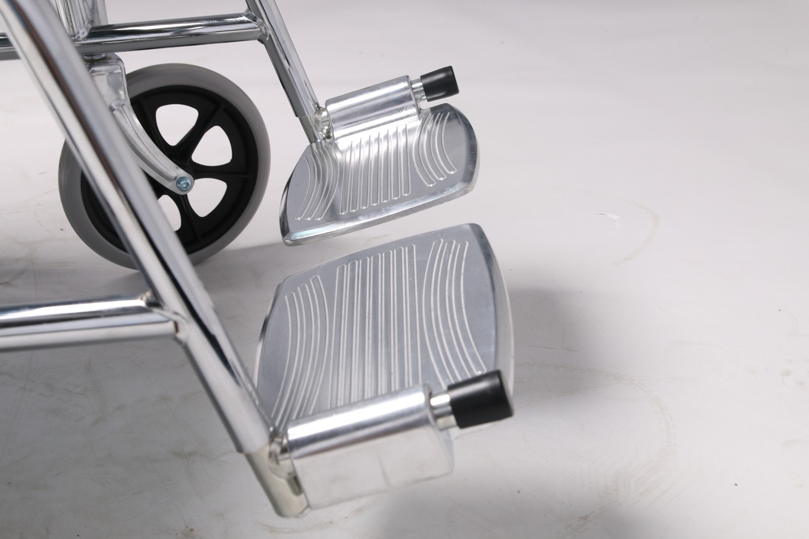 Foldable standard manual wheelchair with large rear wheels, footrests and caregiver push handles in Kenya